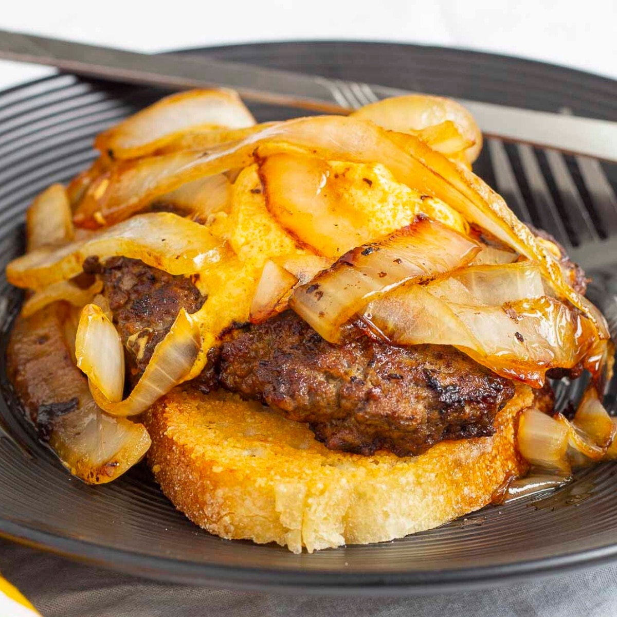 Open-face burger with pub cheese and onions on a plate