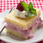 Strawberry Shortcake Cake topped with whipped cream, strawberry and mint on white plate
