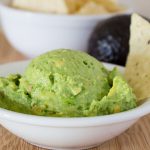 Guacamole with chip in white bowl