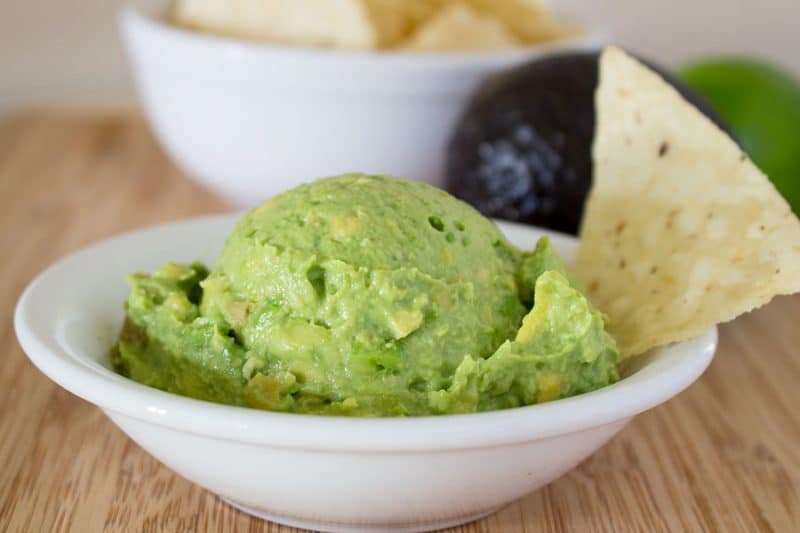 Guacamole with chip in white bowl