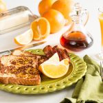 Plated Orange French Toast on green plate set on breakfast table