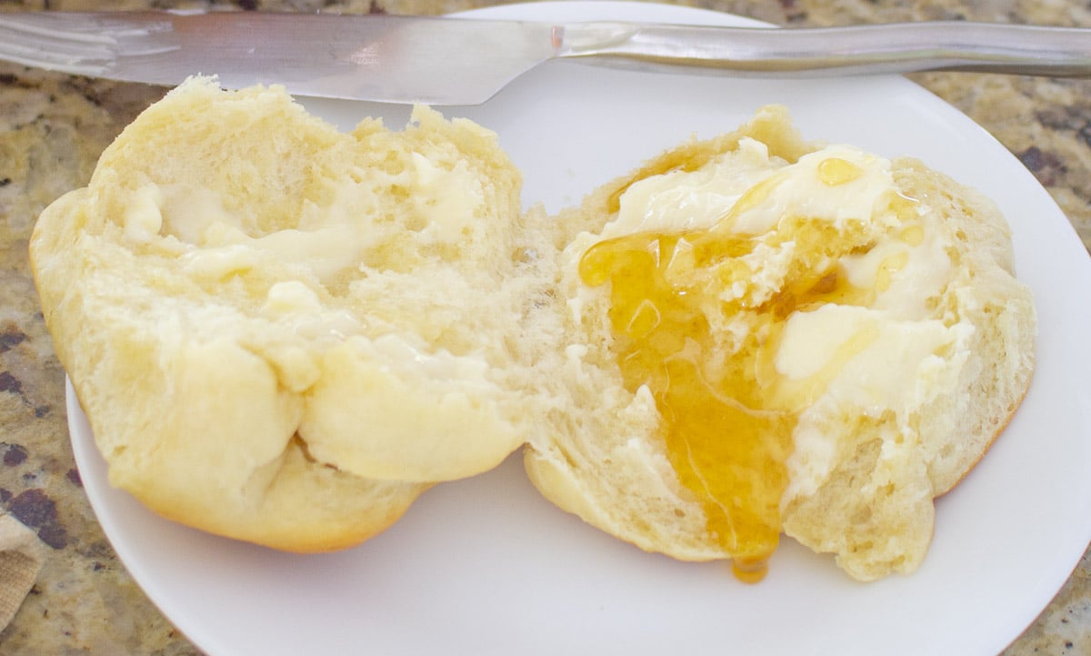 Dinner roll cut in half and covered in butter and honey