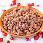 Candied peanuts in a bowl surrounded by christmas balls