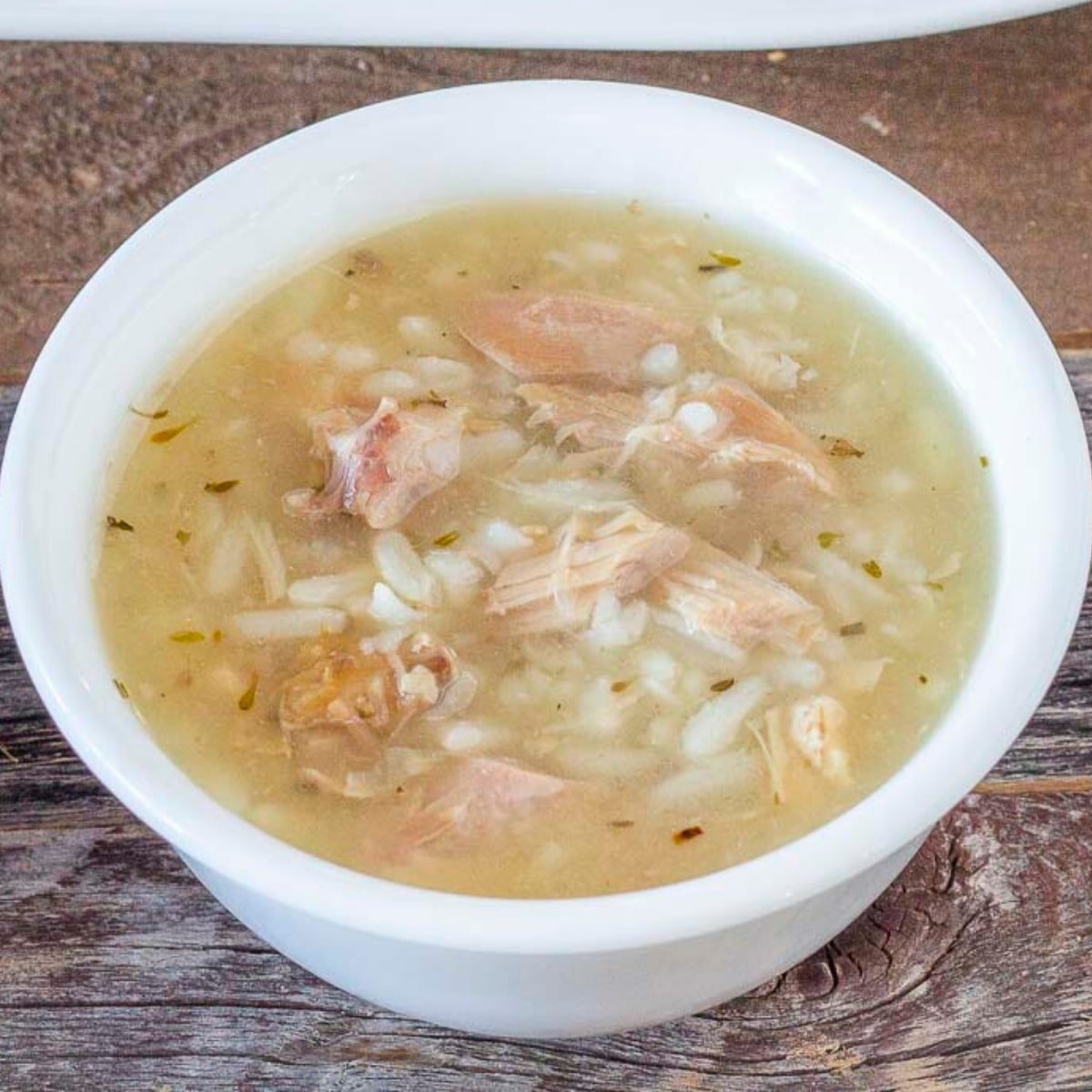 Bowl of soup with turkey pieces, rice, and herbs