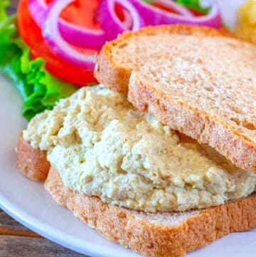 Dijon chicken salad on wheat bread with lettuce tomato and red onion
