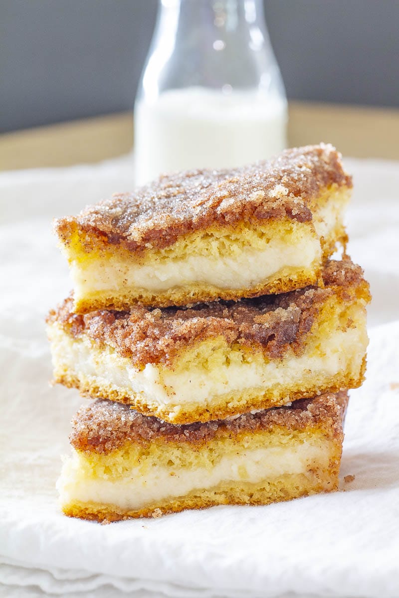 Sopapilla Cheesecake Squares stacked in front of a milk jug