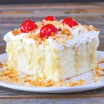 Piece of coconut cake topped with cherries
