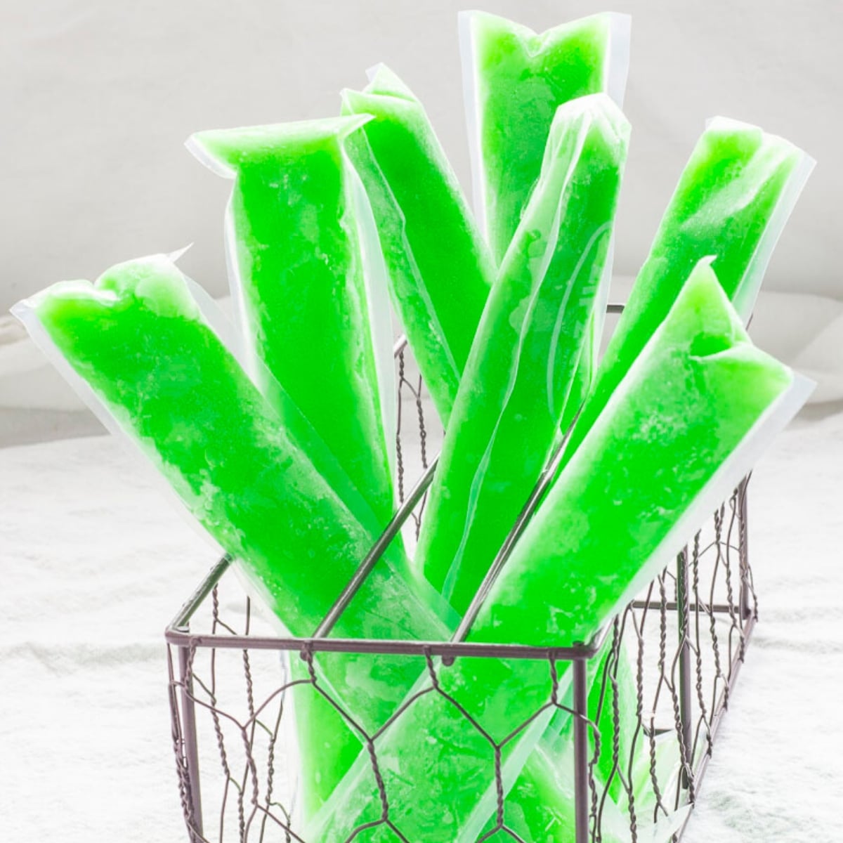 Neon green ice pops in a wire basket