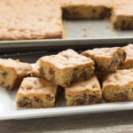 Large Batch Chocolate Chip Cookie Bars stacked on white rectangle plate