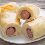Split Sausage Rolls stacked on white plate
