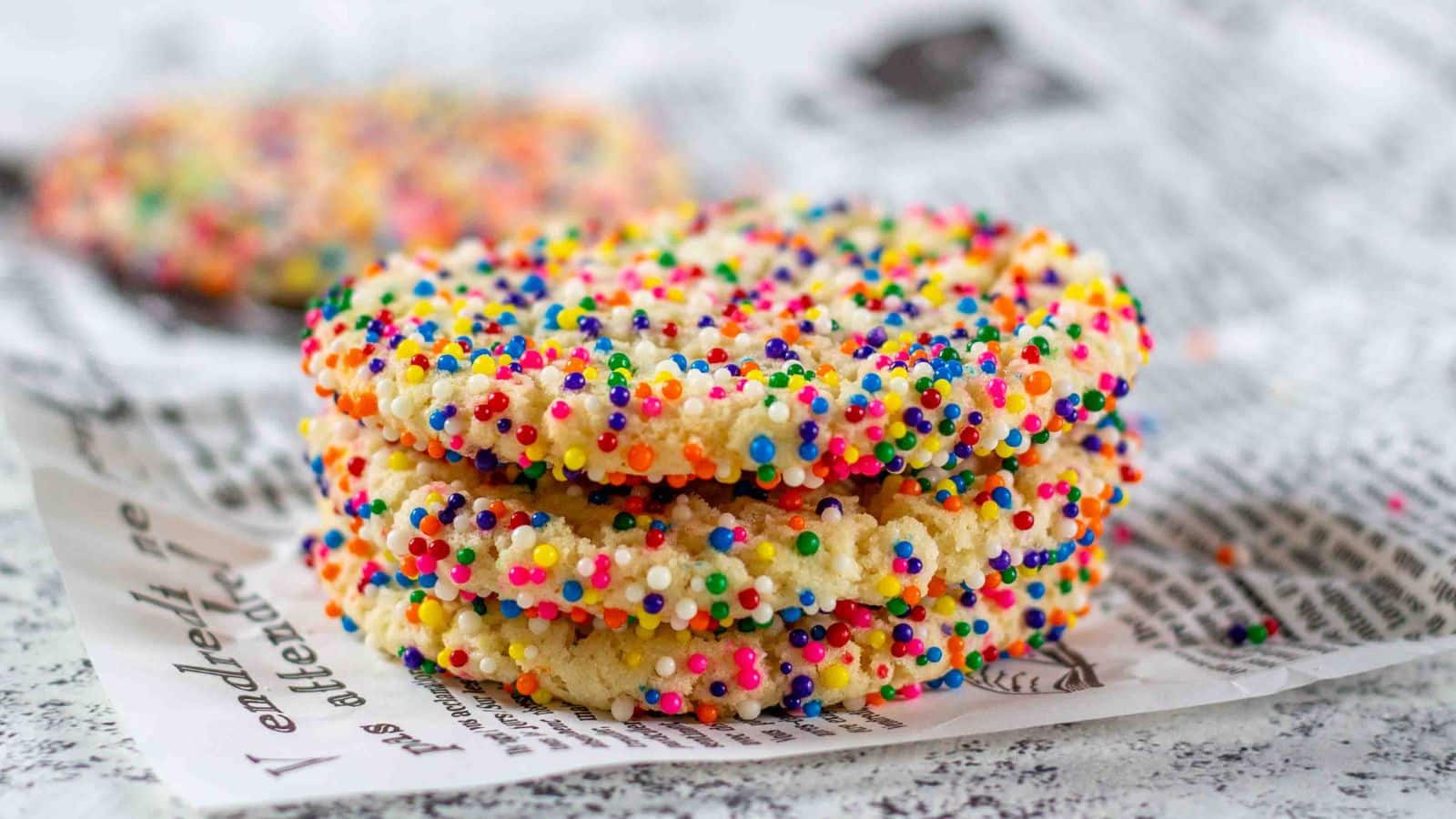 Stack of sprinkle cookies on a wrinkled paper