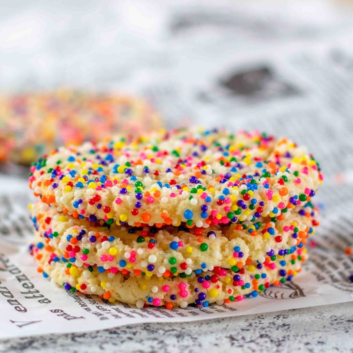 Stack of sprinkle cookies on a wrinkled paper