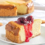 Slice of cheesecake covered with a cherry sauce on a plate