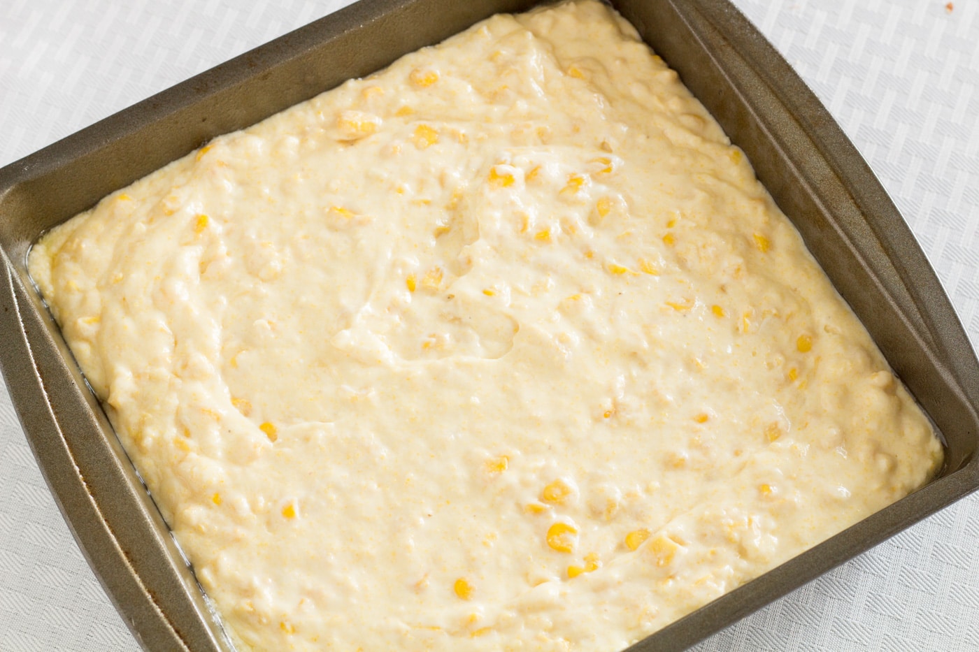 Uncooked Jiffy Corn Casserole in a baking pan