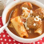 Meatballs rigatoni and mozzarella cheese with tomato broth ina white bowl