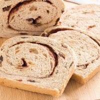 sliced loaf of cinnamon swirl raisin bread on a cutting board