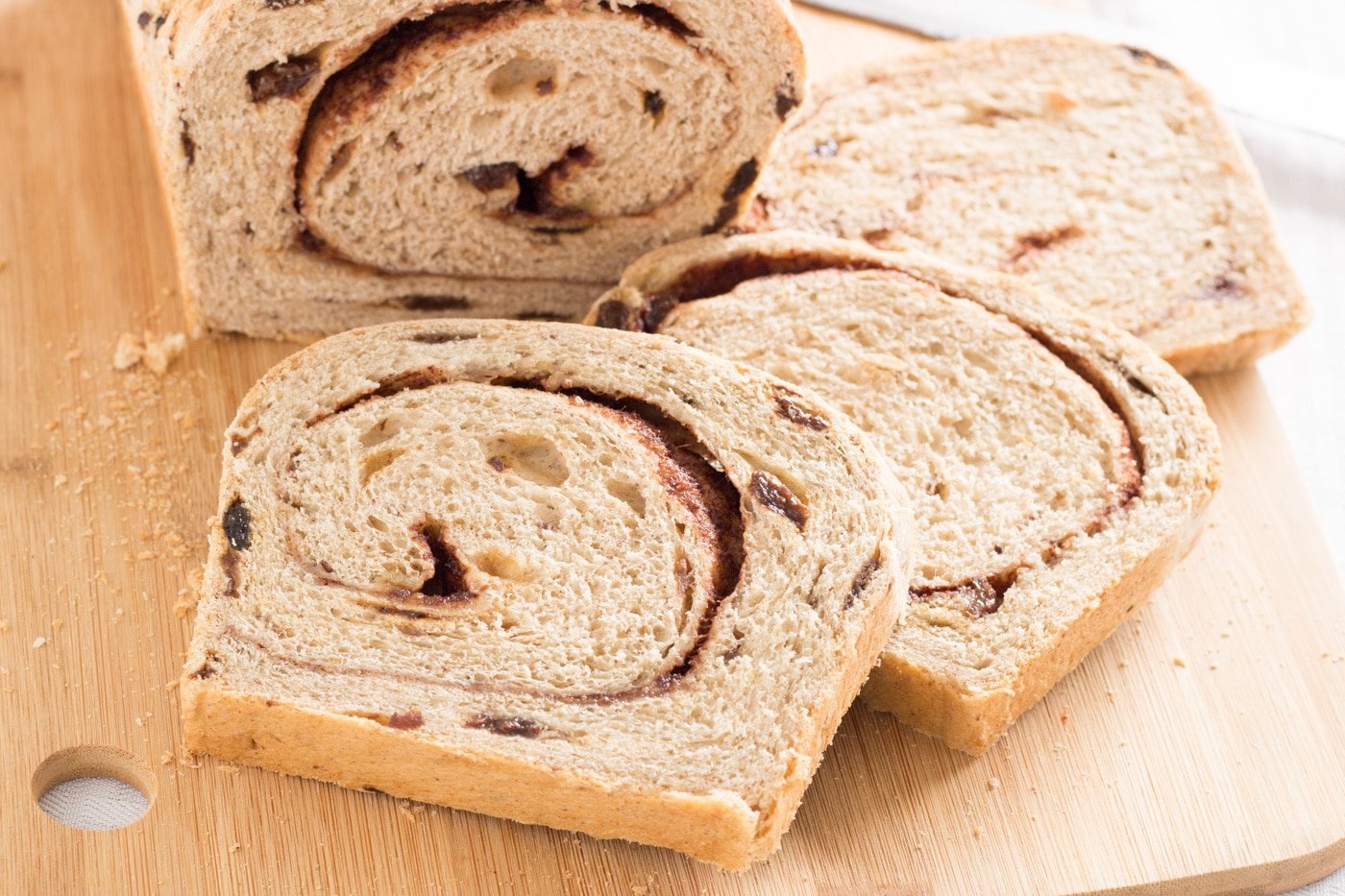sliced loaf of cinnamon swirl raisin bread on a cutting board