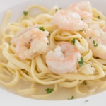 garlic shrimp on pasta with broth in a bowl