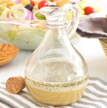 Homemade Italian Dressing in a Bottle with an Italian salad in the background
