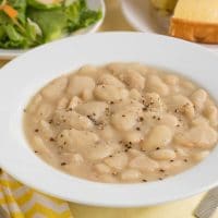 Classic butter beans with cracked black pepper in a white bowl