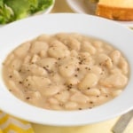 Classic butter beans with cracked black pepper in a white bowl
