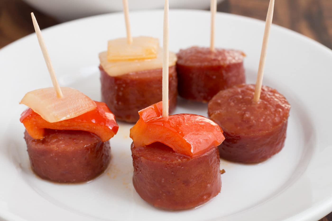 Smoked sausage slices with peppers and onions on toothpicks