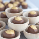 Homemade buckeyes placed in wooden bowls and stacked