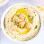Overhead view of hummus in a bowl with whole chickpeas