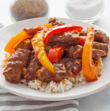 Pepper Steak with rice on a white plate