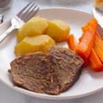 Pot Roast with vegetables on a plate with a fork and knife