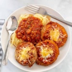 Eggplant Parmesan with spaghetti and sauce on a plate