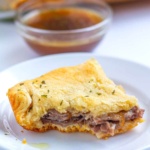 Baked roast beef slider with a bite missing on a plate
