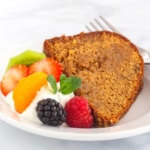 Slice of wine cake with whipped cream and mixed fruit on a plate