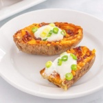 Air Fried potato skins topped with bacon, cheese, sour cream, and green onions