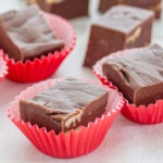 Chocolate fudge pieces with pecans in red paper cups