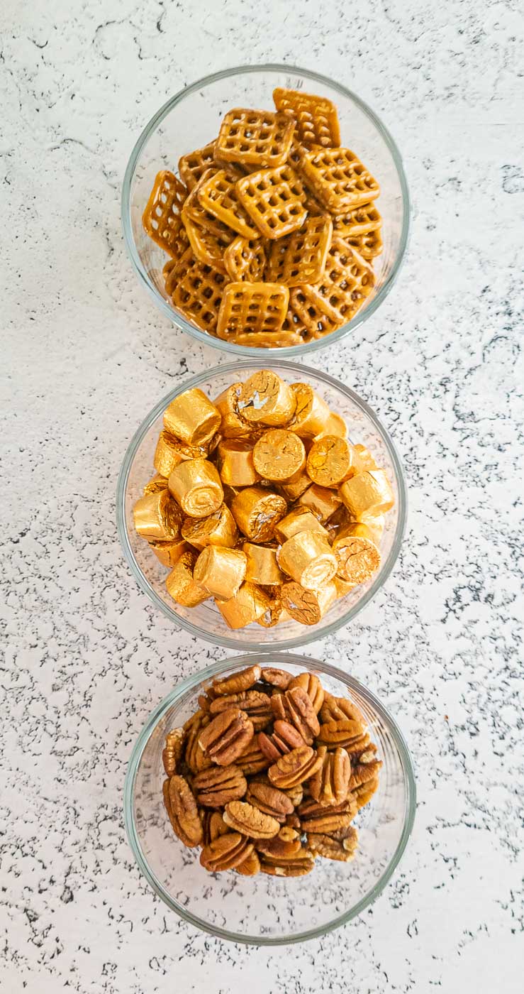 Pretzels, gold foil wrapped candy, and pecans in bowls