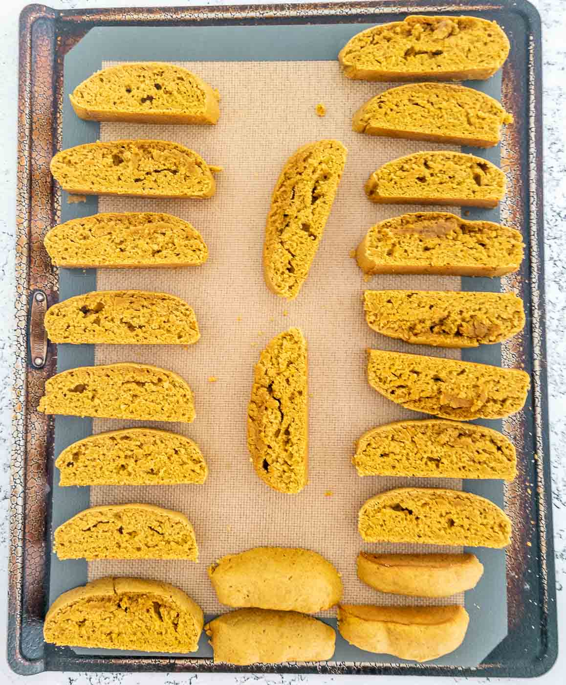 Pumpkin biscotti cut into slices after the first bake and placed back on a baking sheet