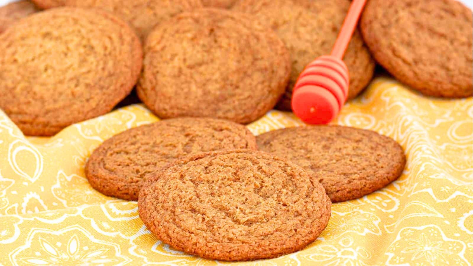 honey cookies on a yellow napkin with a honey dipper