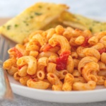 Macaroni and tomatoes served on a big white plate