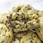 plate of chocolate chip cookies with one broke in half on top