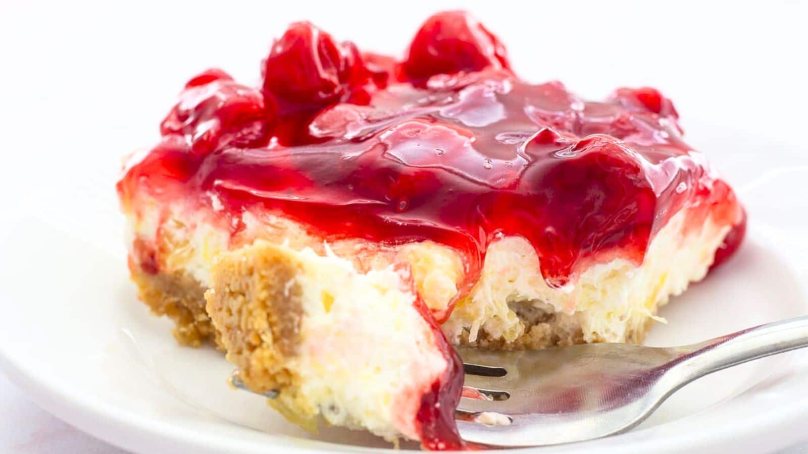Slice of Cherry Delight on a plate with a fork
