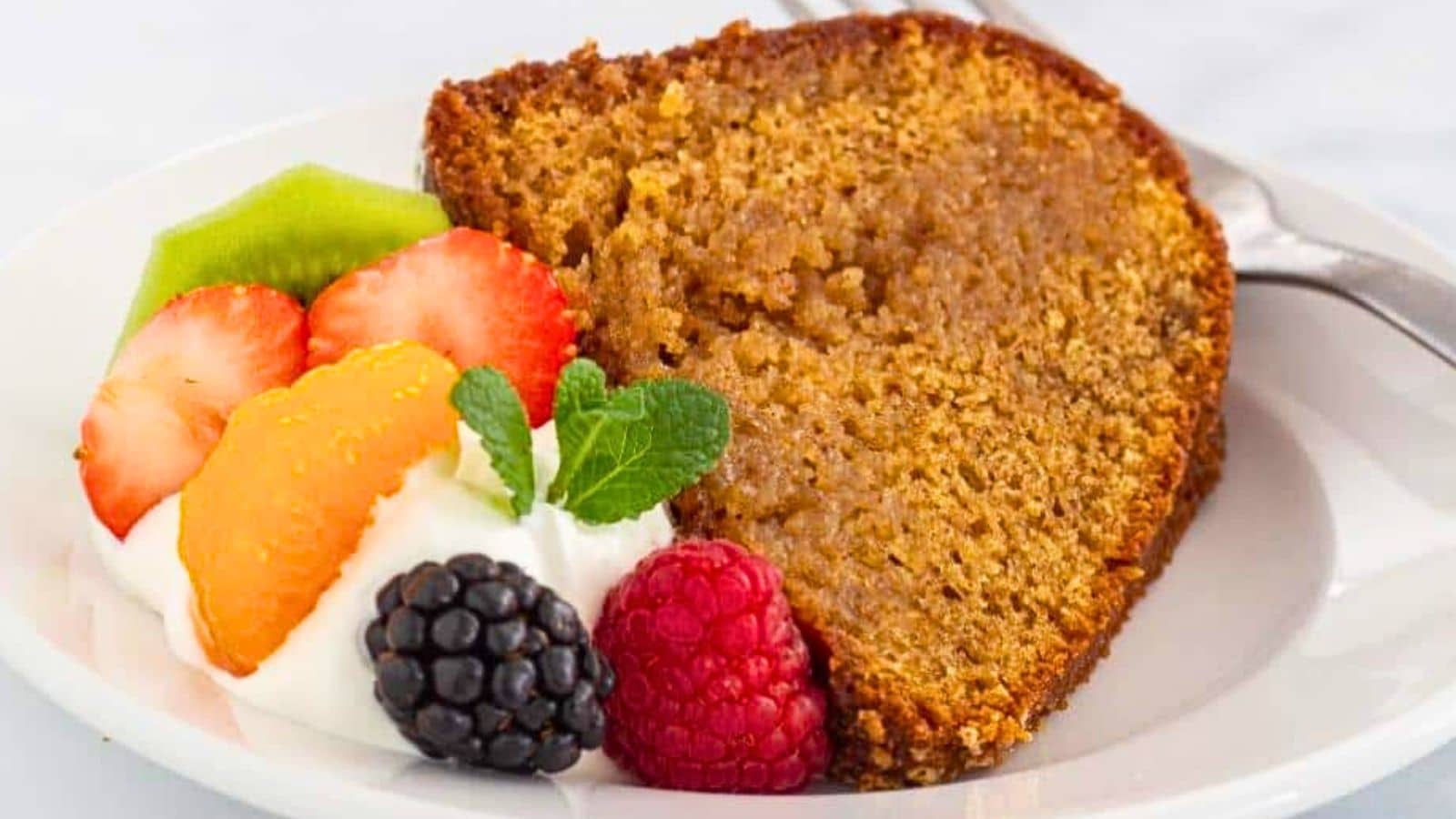 Wine soaked cake on a plate with whipped cream and fruit