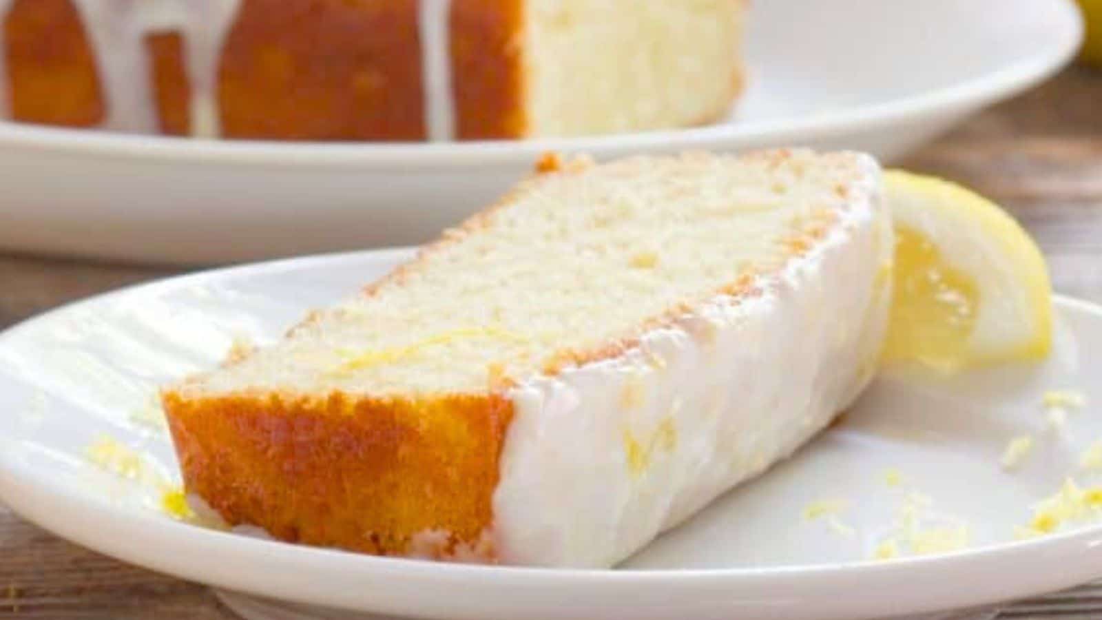 Slice of lemon cake on a plate with a lemon