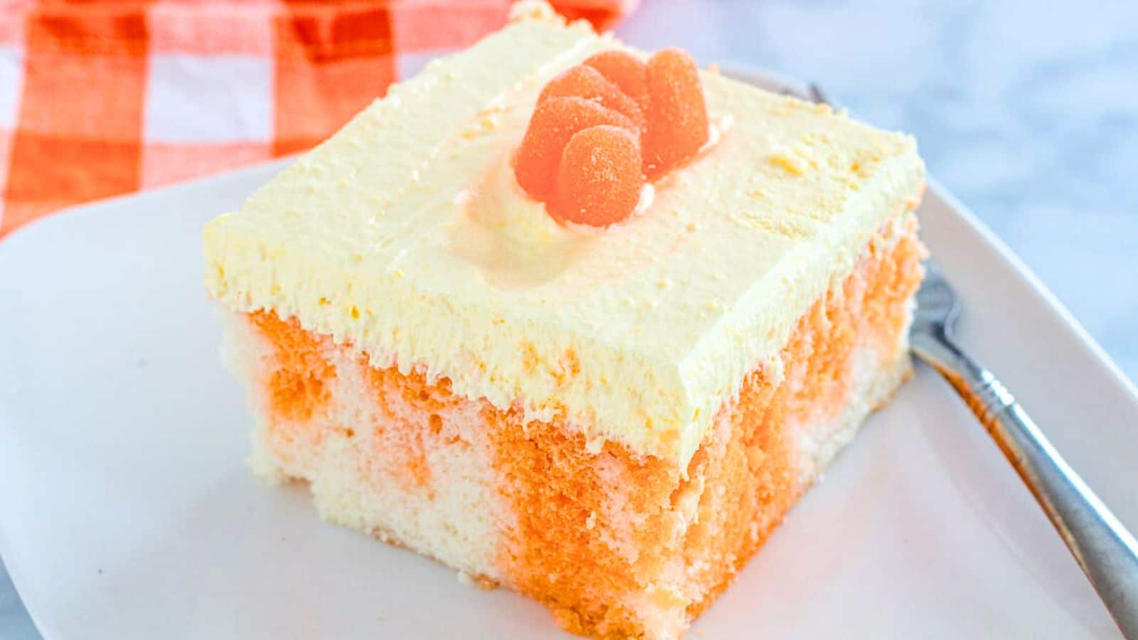 Orange creamsicle cake slice on a plate