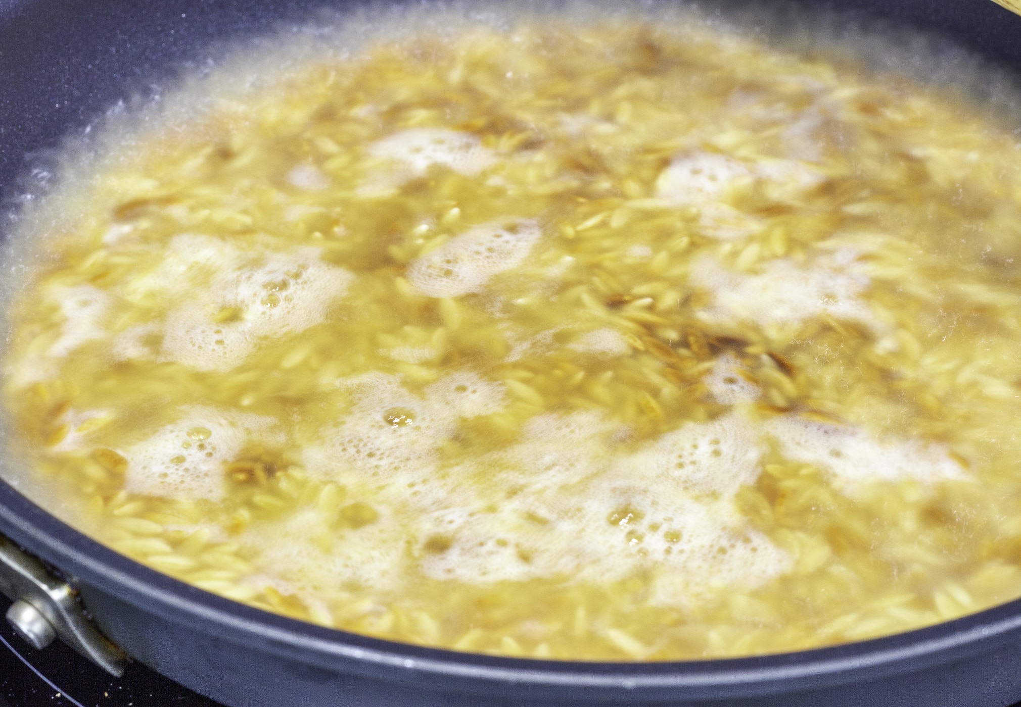 Chicken broth and pasta in a skillet
