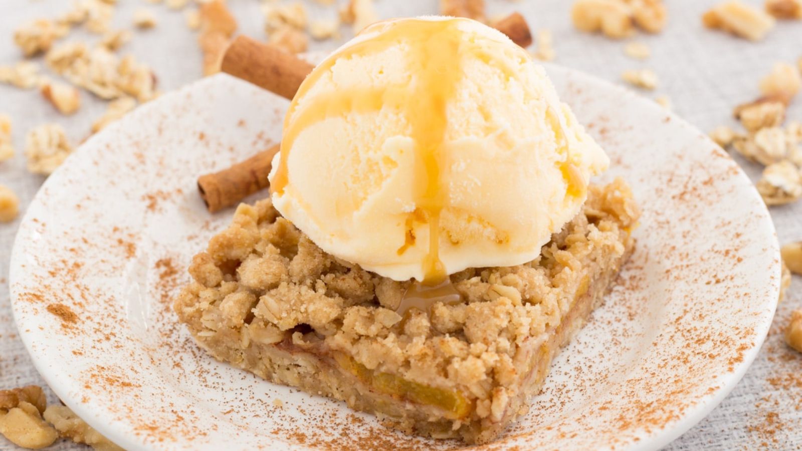 Peach Crumb Bar topped with ice cream on a plate