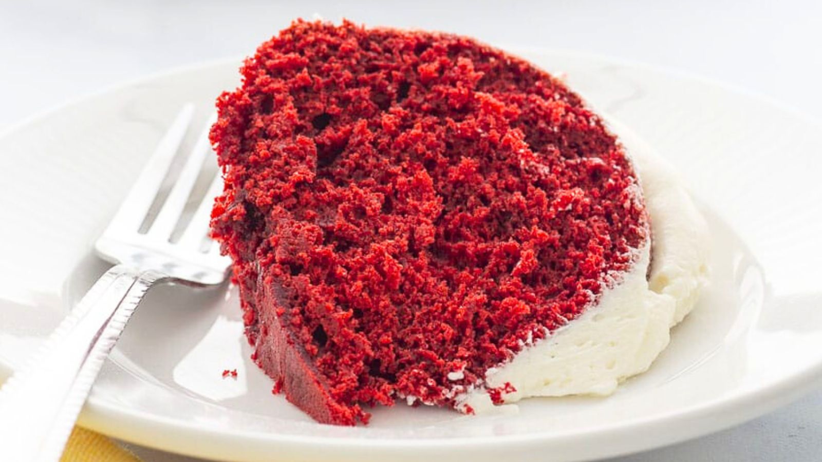 Red cake on a plate with a fork