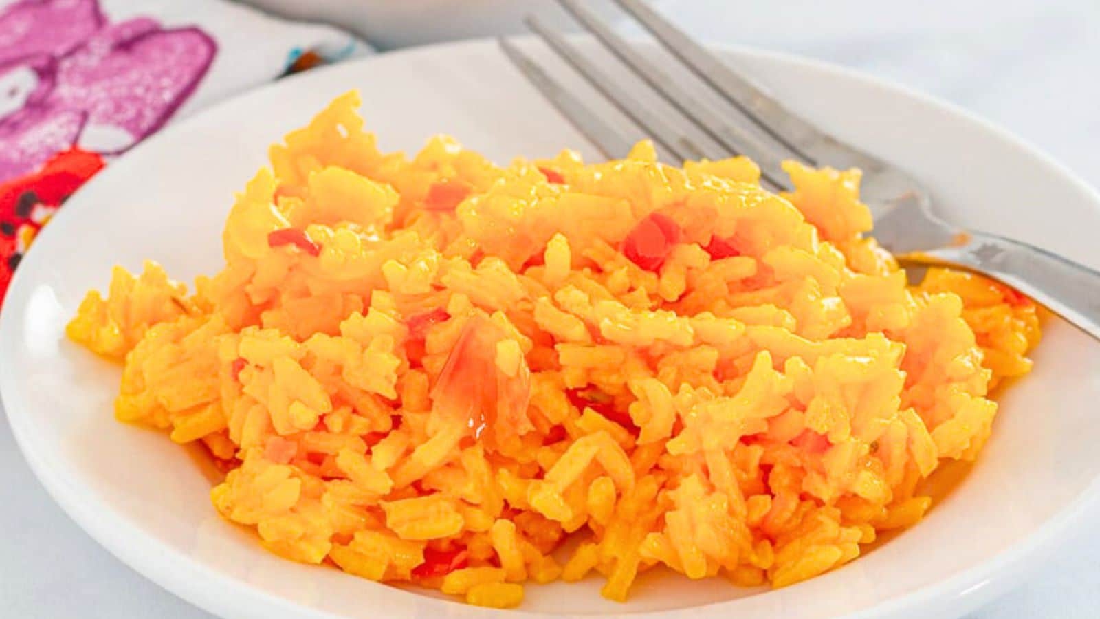 Yellow rice with spices on a plate with a fork