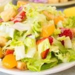 Green salad with strawberries and mandarin oranges on a plate