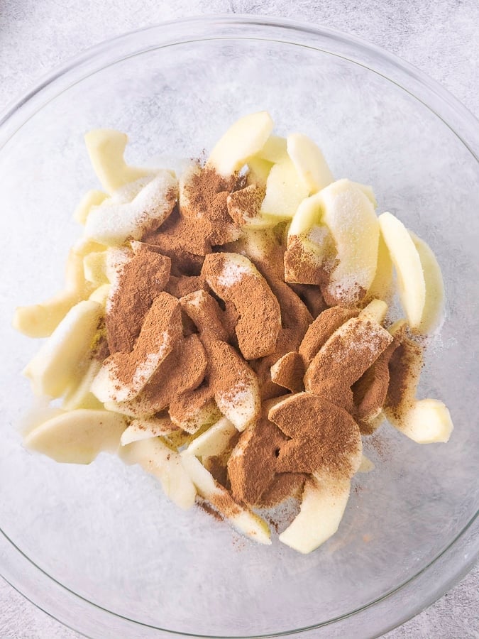 Apple slices sugar and cinnamon in a bowl